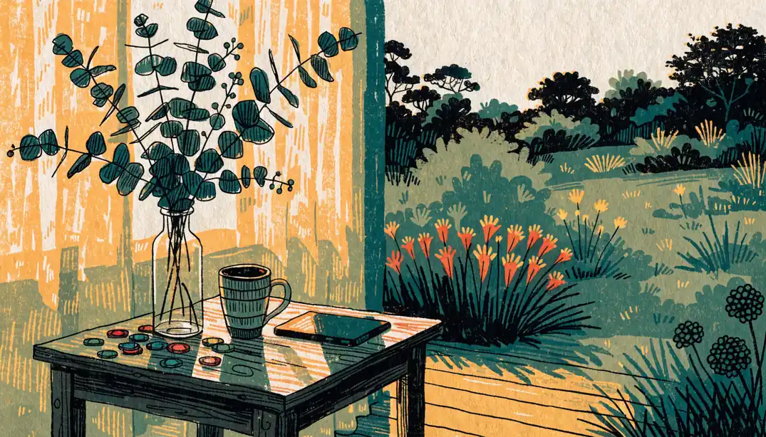 Australian veranda at golden hour with poker chips, eucalyptus vase, and face-down tablet on wooden table.