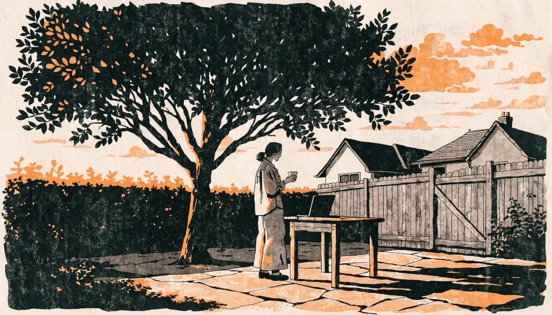 Woman in an Australian backyard with closed gate, laptop face-down on table, golden hour light